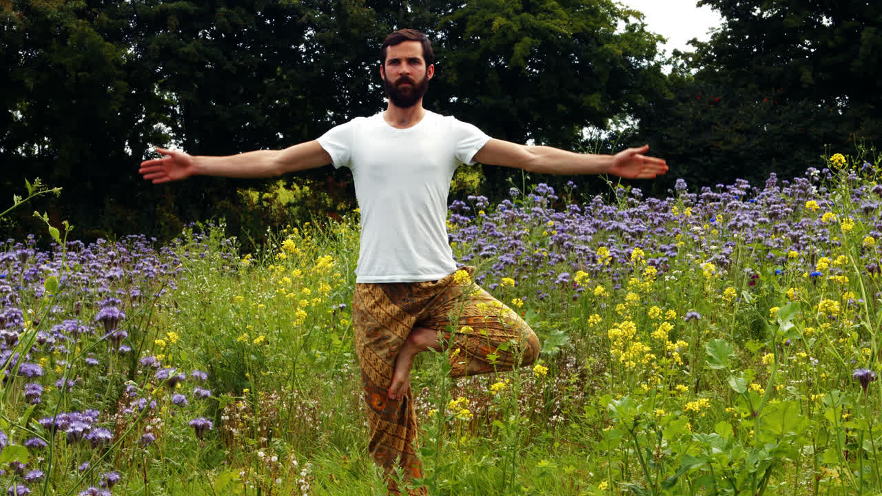 Adam bir tarlada yoga yapıyor.