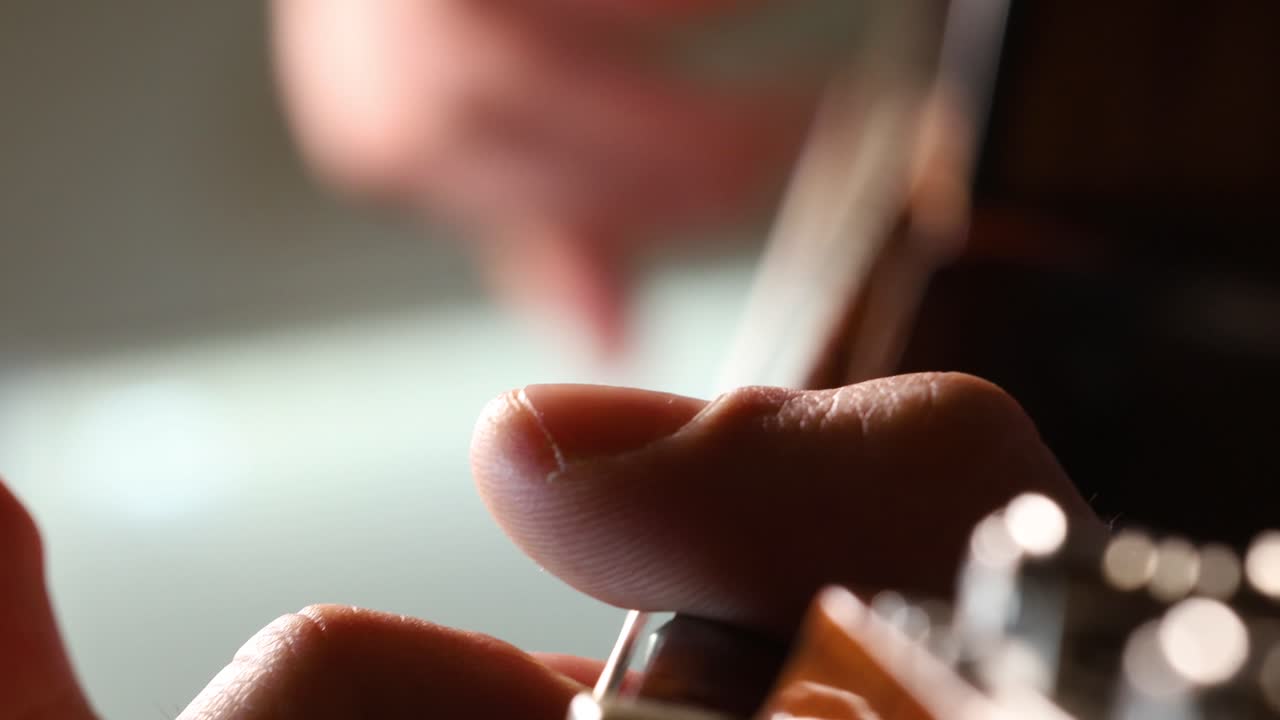 Male guitarist plucking the strings of a spanish guitar