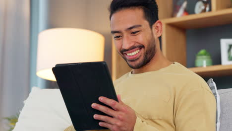 Relaxed-young-man-reading-an-ebook-on-his-digital