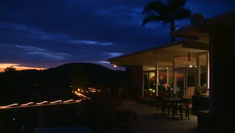 Tilt-down-shot-of-the-deck-of-a-hillside-home-at-twilight