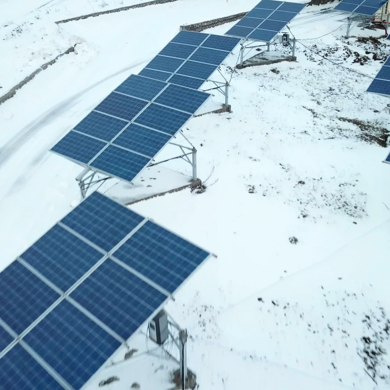 Rows of snow covered solar panels in small solar power plant. Solar power plant on the outskirts of the city.