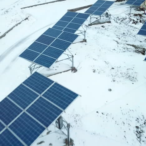 rows of snow covered solar panels in small solar power plant. solar power plant on the outskirts of the city.