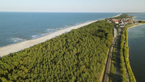 Aerial-shot-Hel-Peninsula,-cinematic-shot-over-gren-forest-near-road-and-sea-baltic