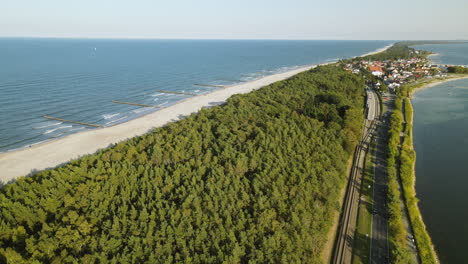 aerial shot hel peninsula, cinematic shot over gren forest near road and sea baltic