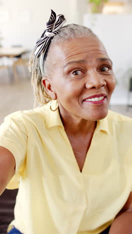 vertical video: a senior african american woman with bright smile is looking up