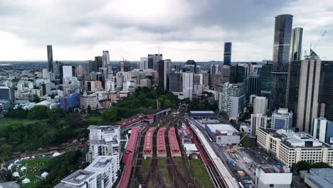 roma street train station with the towering urban skyline of brisbane city metropolitan area. aerial drone view