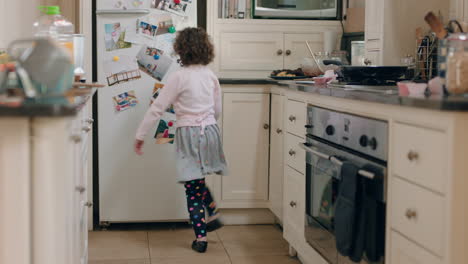 happy little girl dancing in kitchen having fun doing funny dance moves enjoying weekend at home