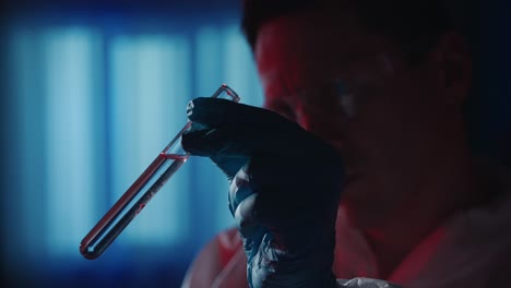 scientist examining test tube with liquid sample