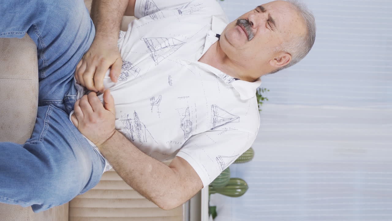 Vertical video of Old man with stomachache.