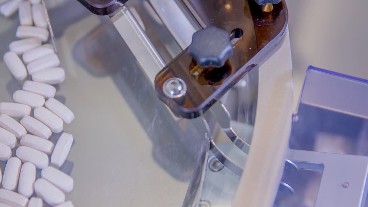 Primo piano di pillole bianche che ruotano su una macchina di imbottigliamento in un laboratorio farmaceutico