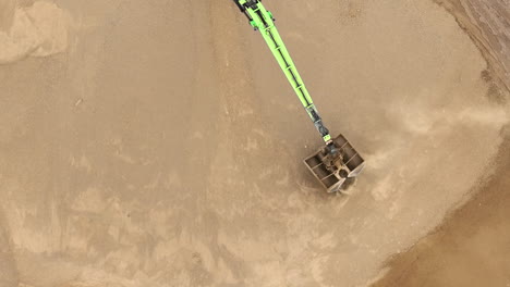 an aerial view of a large dump truck filled with sand, showing tire tracks and the surrounding worksite