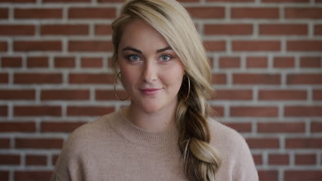 portrait-beautiful-young-blonde-woman-smiling-looking-surprised-shocked-female-student-on-brick-wall-background-wearing-earings