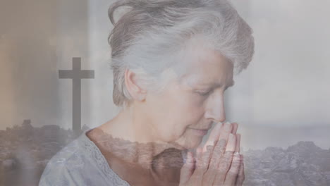 praying over cross and rocky landscape animation, elderly woman showing devotion