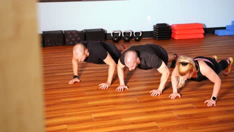 hombres y mujeres realizando flexiones