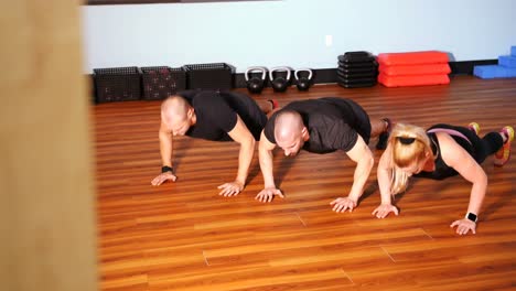 men and woman performing push ups