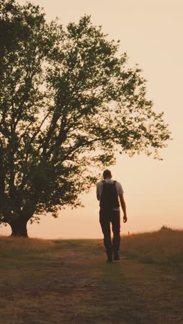 hombre caminando por un camino al atardecer