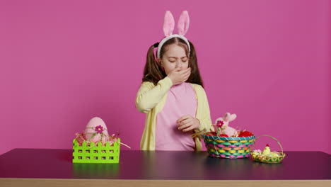 exhausted little child decorating festive ornament for easter sunday celebration