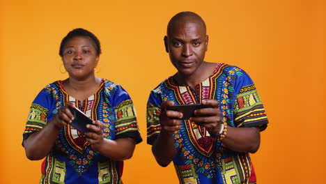 ethnic couple having fun with mobile videogames on phone