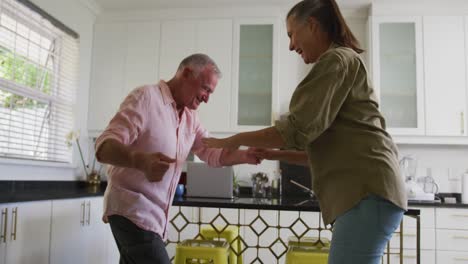 Pareja-Mayor-Caucásica-Bailando-Juntos-En-La-Cocina-De-Casa