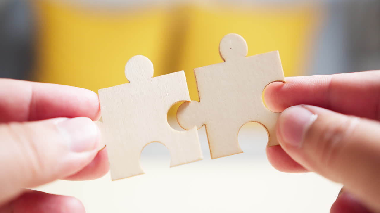 cerca de las manos de los hombres conectando rompecabezas