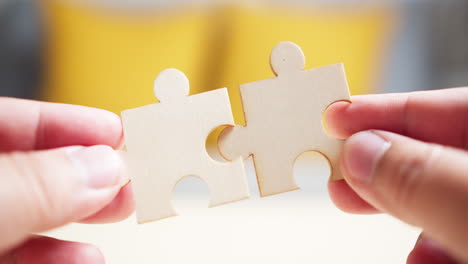 close up hands of men connecting jigsaw puzzle