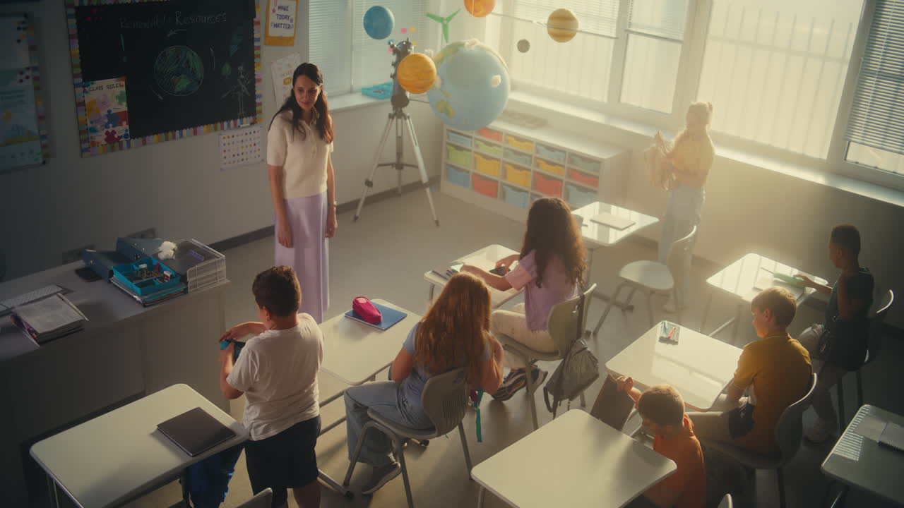 Female Teacher Finishing Lesson Announcing the End of School Day to Diverse Kids