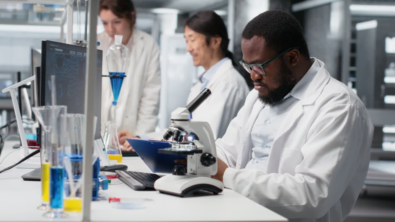 Vertical video Clinical microbiologist operating compound microscope, recording findings