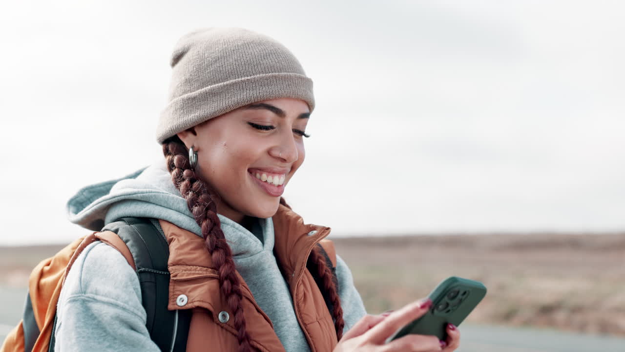 Woman using mobile phone on desert road