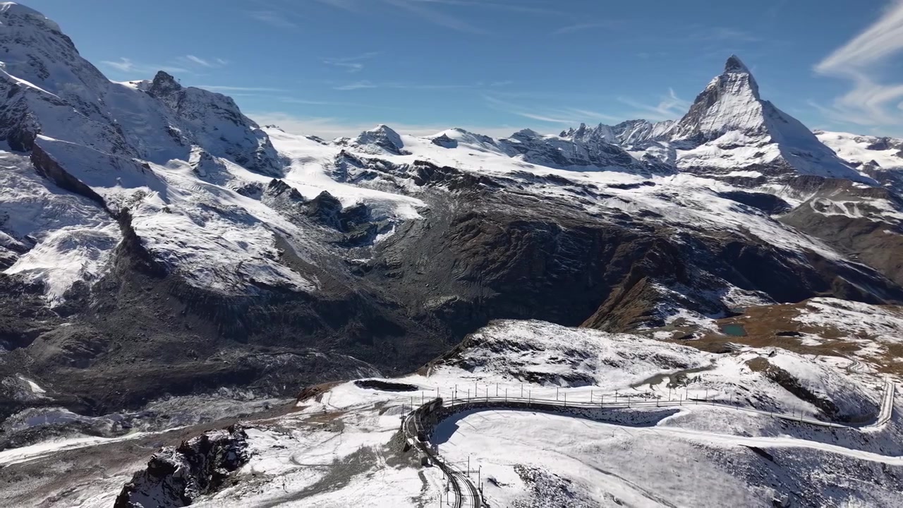 Drohnenüberflug über die Gornergratbahn in Zermatt, Schweiz, mit Blick auf das Matterhorn an einem verschneiten Herbsttag in den Schweizer Alpen