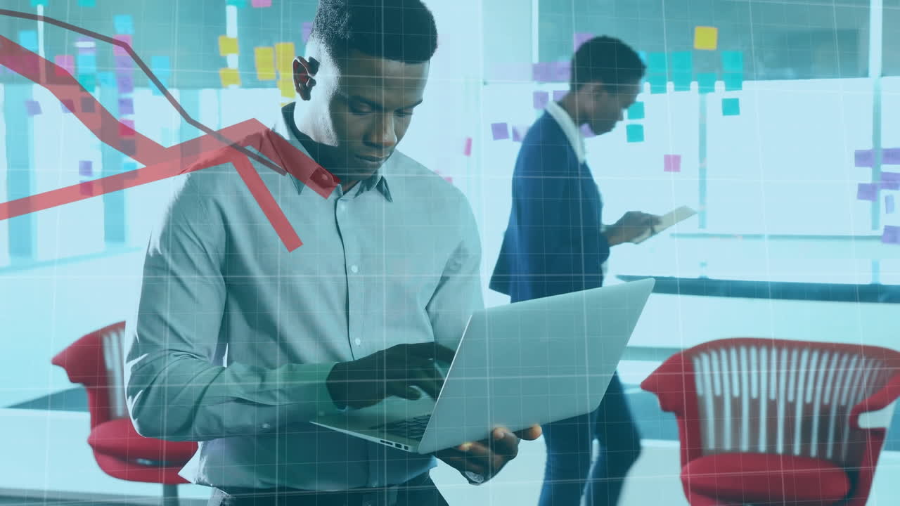 Animation of financial data processing with red lines over african american businessman using laptop