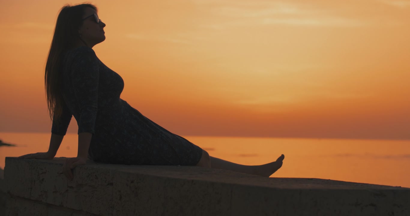 Woman enjoying beautiful sunset