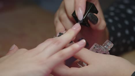 Manicure---Manicurist-Applying-Clear-Nail-Polish-On-Fingernails-Of-Woman-At-Nail-Salon