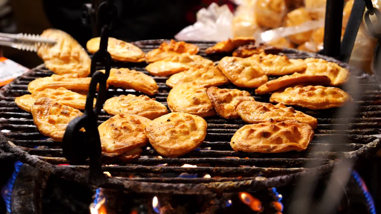 요리사는 오스키페크 (oscypek) 를 뒤집는다. 폴란드 지역 치즈를 철조 그릴에서 불 위에 는다.