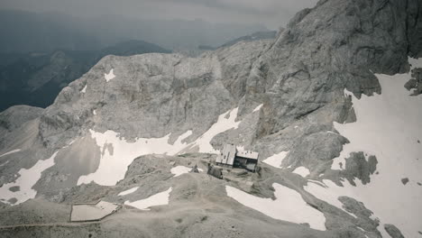 Shot-of-slovenian-mountains-out-of-helicopter-of-a-mountain-cottage-in-Slovenian-Julian-Alps-in-mid-of-summer