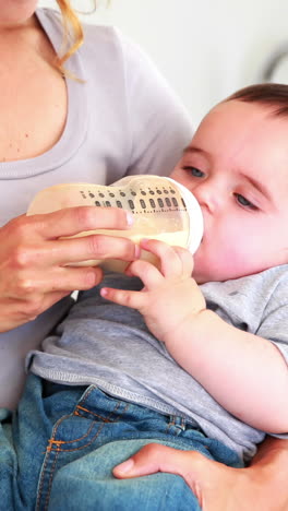 mother feeding her baby boy his bottle
