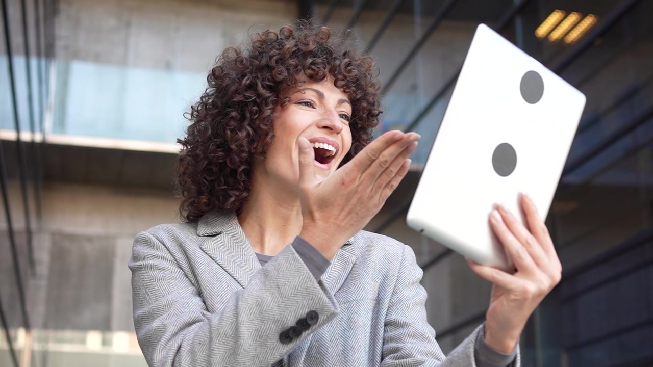Una donna professionista usa un tablet in un ufficio moderno, evidenziando le sue aspirazioni di carriera.