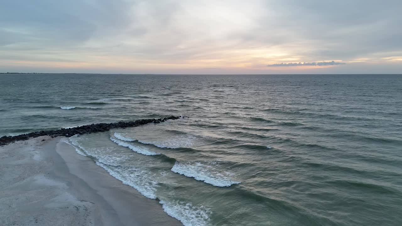 Onde che si infrangono sulla costa di St. Pete Beach al tramonto.