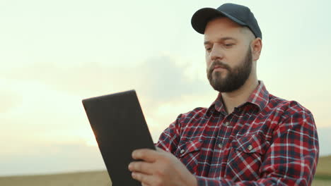 agricultor usando um tablet e observando suas colheitas