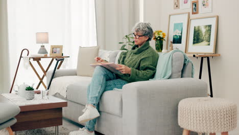 Senior-woman,-book-and-reading-to-relax-in-living