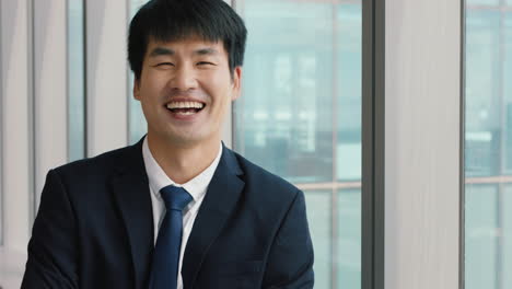 portrait asian businessman laughing happy male executive in office enjoying successful career in corporate leadership company manager at work