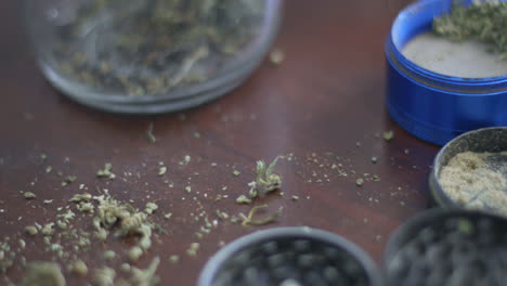 marijuana grinders filled with weed and kief on a wood background