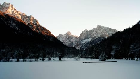 hermoso lago alpino jasna cerca de kranjska gora, eslovenia durante el invierno al atardecer