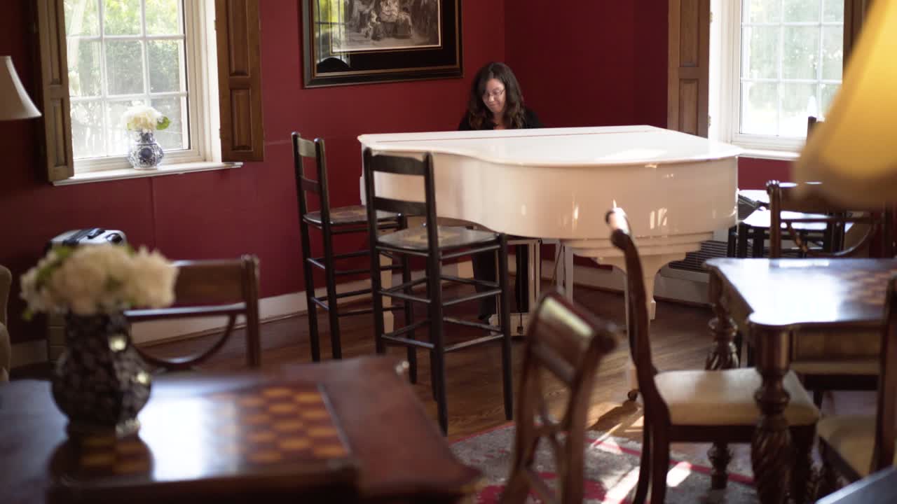 A woman playing the piano in a living room