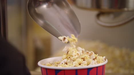 popcorn pouring in container with ladle in slow motion.