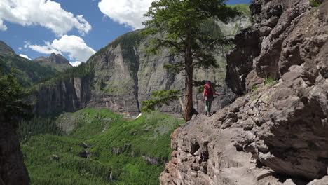 woman on via ferrata climbing route walking in rocks above stunning green valley colorado usa