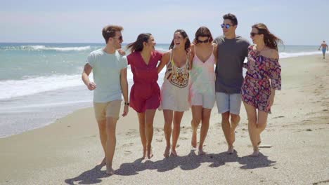 Happy-group-of-young-students-walking-on-a-beach