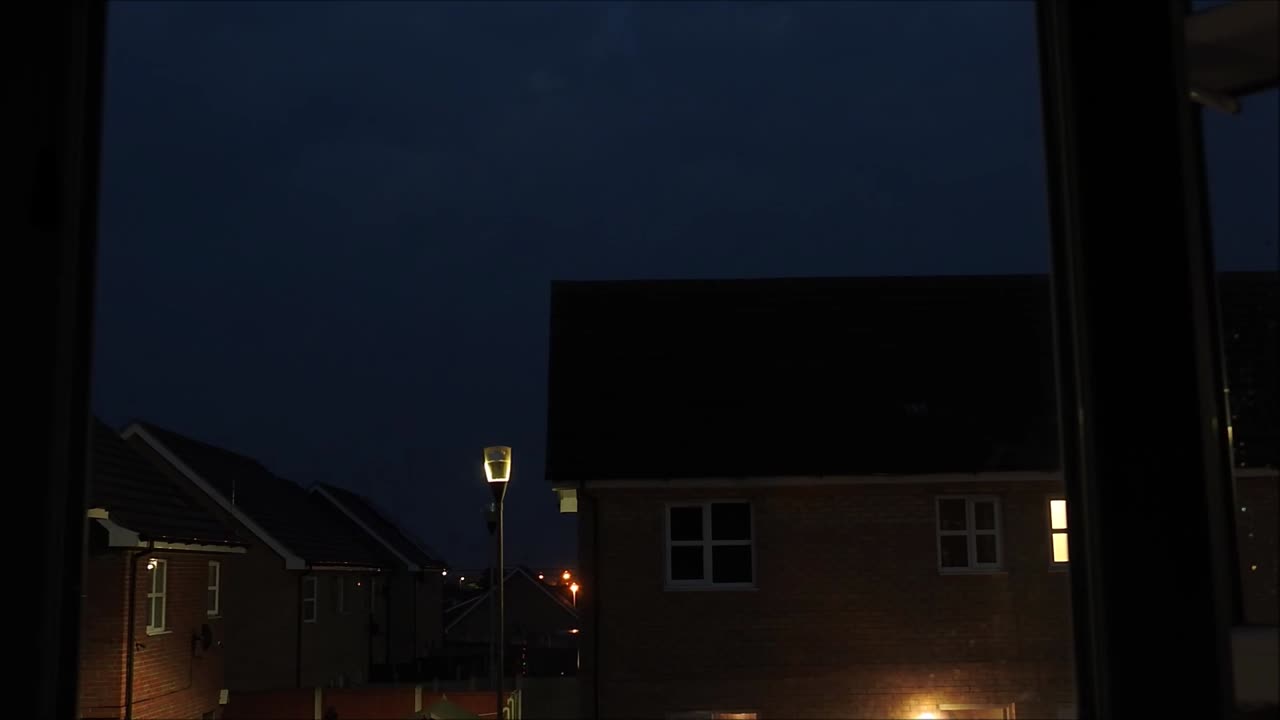 En timelapse af skyer, med forskellige former og farver, der driver over huse i England, Storbritannien