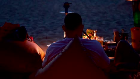 couple enjoying shisha by the ocean