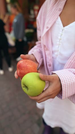 girl holding red and green apples