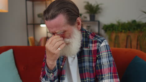 upset disappointed senior grandfather wipes tears and cries from despair, unrequited love, problems